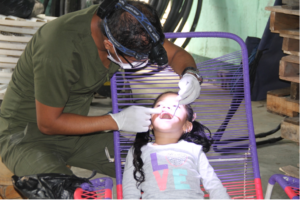 Dentist performing oral exam on young girl