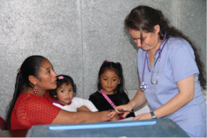 female doctor giving young girl a check up and talking to mom